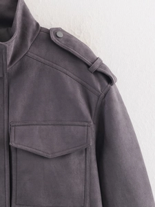 Dettaglio delle spalline e tasche a patta su una giacca utility in camoscio grigio-viola
