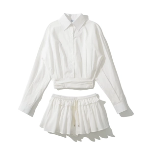 Flat lay of white long sleeve shirt with waist tie and ruffled drawstring shorts set