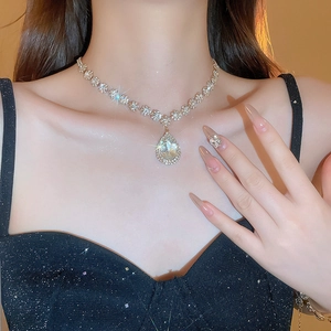Close-up of model wearing a luxury pear-shaped diamond pendant necklace on the neck