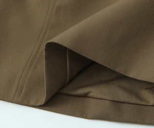 Macro shot of brown sleeveless top fabric showing twill texture and seam stitching detail