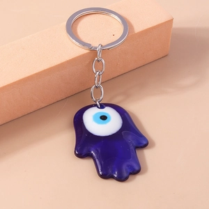 Detail showing the translucent blue Hamsa hand keychain with a classic evil eye charm