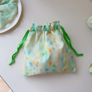 Detail of mint green tie-dye drawstring bag with colorful watercolor polka dots