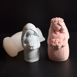 Detail view of Virgin Mary silicone mold with blue and pink handmade candle crafts