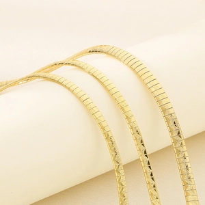 Detailed macro view of gold-plated flat chain necklace with precise herringbone engraving