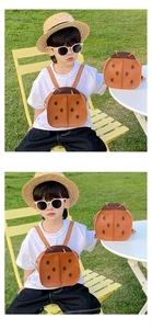 Toddler brown ladybug backpack with PU leather wings shown in an outdoor garden setting