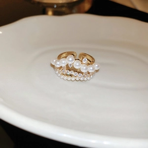Close-up of 18K gold plated bow ring featuring white pearls and sparkling cubic zirconia