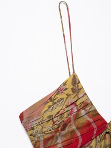 Detailed view of floral midi dress with yellow and red prints and pleated fabric texture