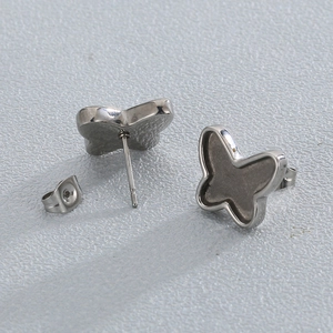 Macro shot of silver butterfly stud earrings with dark grey enamel inlay details