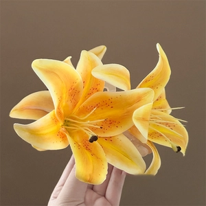 Elegant purple lily claw clip with realistic yellow petals and orange spots held in hand