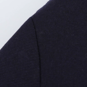 Close-up of the shoulder seam stitching and woven texture on a navy wool coat