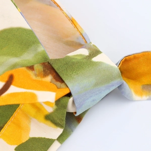 Détail macro d'un nœud en tissu floral jaune et vert avec des coutures soignées