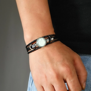 Gros plan d'un bracelet en cuir tressé noir avec pendentif à motif marbre au poignet