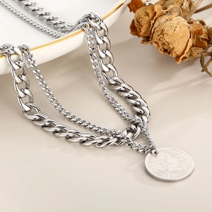 Detail of silver double-layer necklace with chunky chain and queen coin pendant