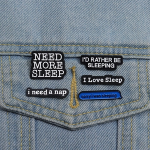 Makroaufnahme von 5 Emaille-Schlaf-Pins im Set auf einer blauen Jeansjacke