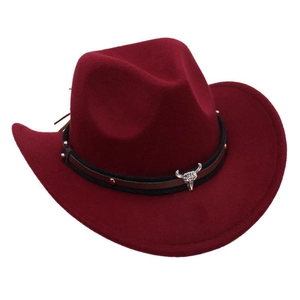 Detail of burgundy felt cowboy hat featuring silver bull skull and bronze studs