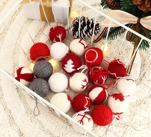 Macro view of knitted Christmas ball set with snowflake embroidery in a white metal basket