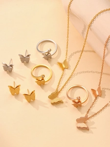Flat lay of butterfly jewelry set featuring necklaces rings and studs in gold and silver