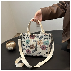 Detail view of floral print canvas tote bag with adjustable shoulder strap and handles