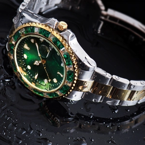 Macro shot of waterproof watch with green dial and gold-silver steel band on water surface