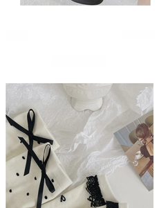 Close-up of white cotton socks with black polka dots, lace trim and ribbon bows