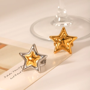 Close-up of polished stainless steel star-shaped rings in gold and silver finish
