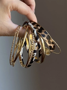 Detail of 10-piece bohemian gold metal and leopard print leather wrap bracelet set