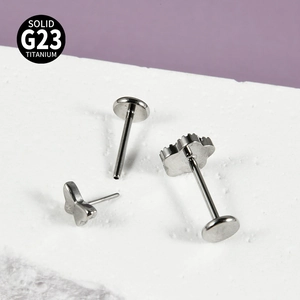Piercing labret papillon en titane G23 avec zircons posé sur une pierre blanche