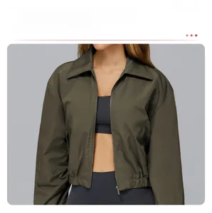 Detail of army green sports jacket showing stand collar, zipper, and windproof fabric