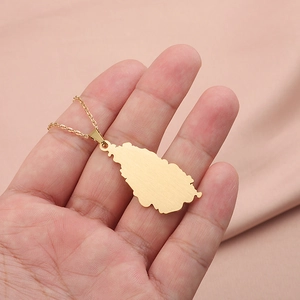 Golden stainless steel Germany map pendant necklace held by hand on pink cloth background