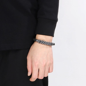Detail of woven leather bracelet with stainless steel bike chain on male wrist