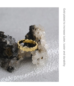 Macro shot of scalloped gold plated ring on raw stone showing high polish finish