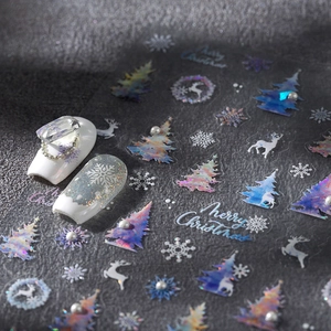 Holographic Christmas nail art stickers with reindeer and snowflakes on dark rock background