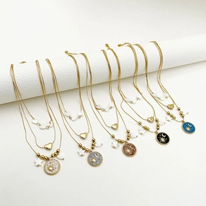 Detail of bohemian layered gold chains with celestial sun moon heart enamel charms
