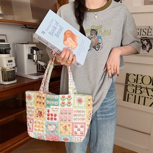Detailed patchwork quilted tote bag with floral prints shown in a vintage cafe setting
