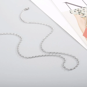 Polished silver stainless steel chain necklace for men and women on a grey background