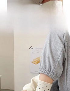 Detail of soft cream-colored knit arm sleeves with polka dots and seamless wide compression