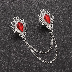 Detail of gothic silver collar brooch with red gemstone waterdrops and dual chains