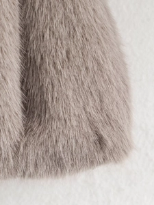Detail shot of soft faux fur texture on a light brown women's casual autumn jacket