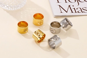 Close-up of polished gold and silver Tree of Life cutout wide rings in a set of six