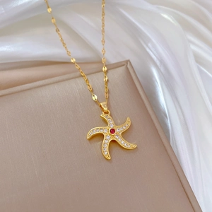 Luxury gold spinning starfish pendant necklace with clear crystals and a center red gemstone