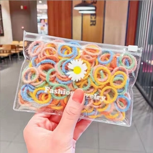 Close-up of colorful plush elastic hair bands in a transparent daisy branded package