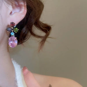 Close-up of model wearing colorful zircon flower drop earrings with pink oval stones