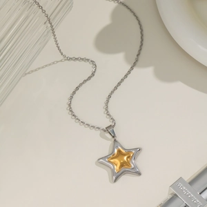Macro view of two-tone star pendant necklace with gold center and silver outer ring