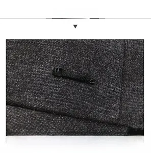 Detail of dark grey tweed wool baseball cap featuring a metal logo and premium texture