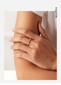 Close-up of wavy gold-plated titanium steel ring with white pearls on model finger