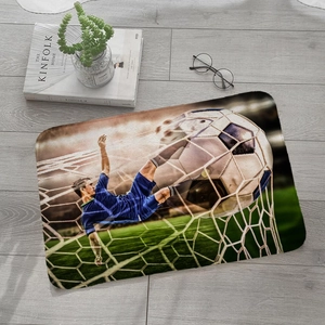 Detail of soccer themed absorbent flannel mat on grey wooden floor in a cozy home setting