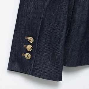 Manica di blazer in denim blu scuro con tre bottoni decorativi in oro lucido sul polsino