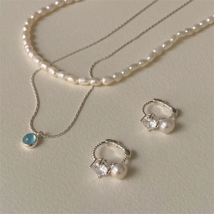 Detail of a 925 silver jewelry set with double-layer pearl necklace and zircon earrings