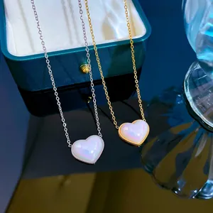 Dettaglio macro dei ciondoli a cuore iridescenti su collane in titanio oro e argento