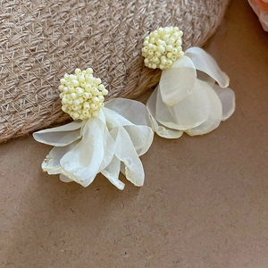 Close-up of handmade chiffon flower earrings with creamy yellow beads and white petals
